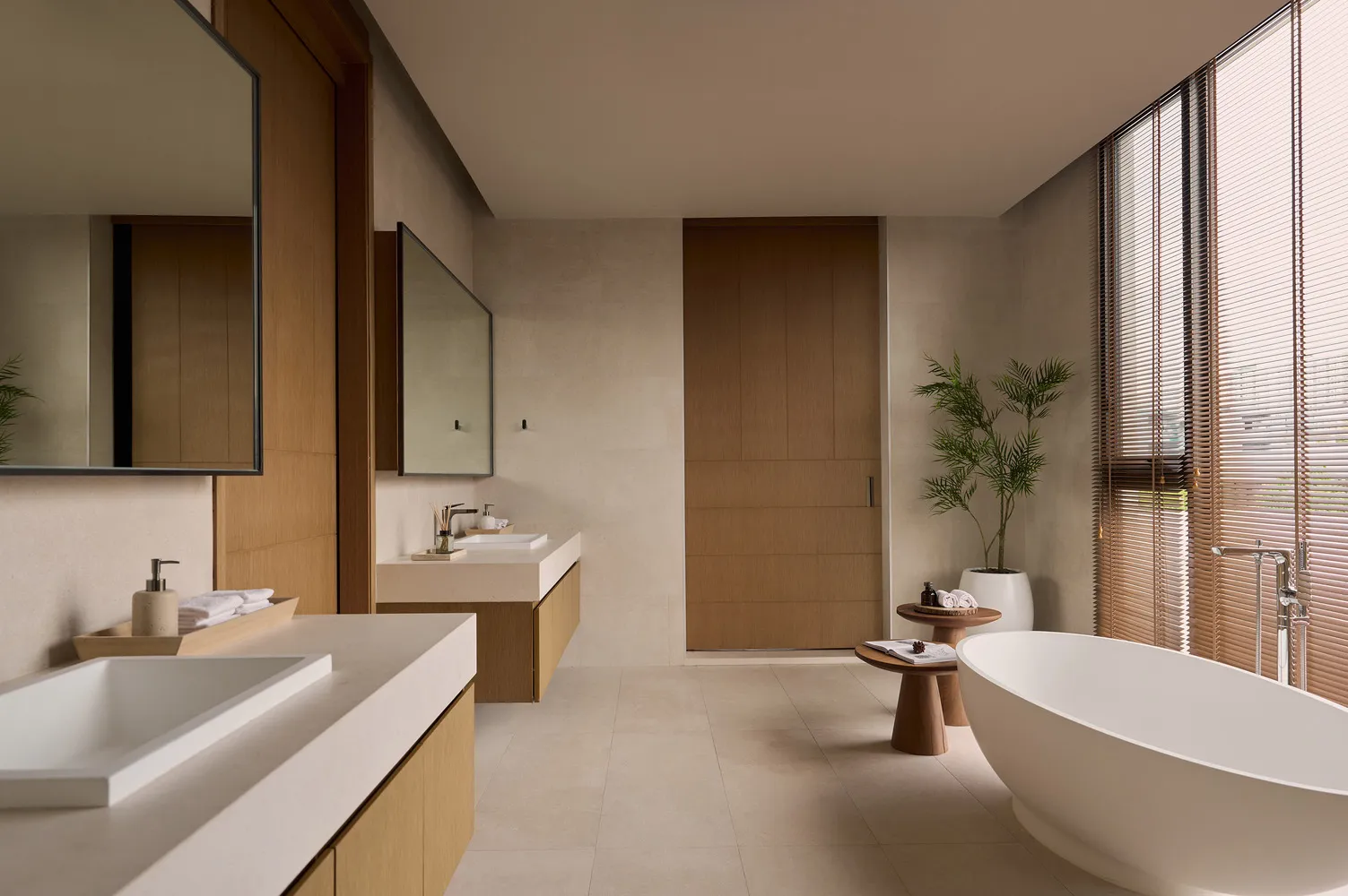 Modern bathroom with wooden doors, stone sink, and concrete floor and tub.