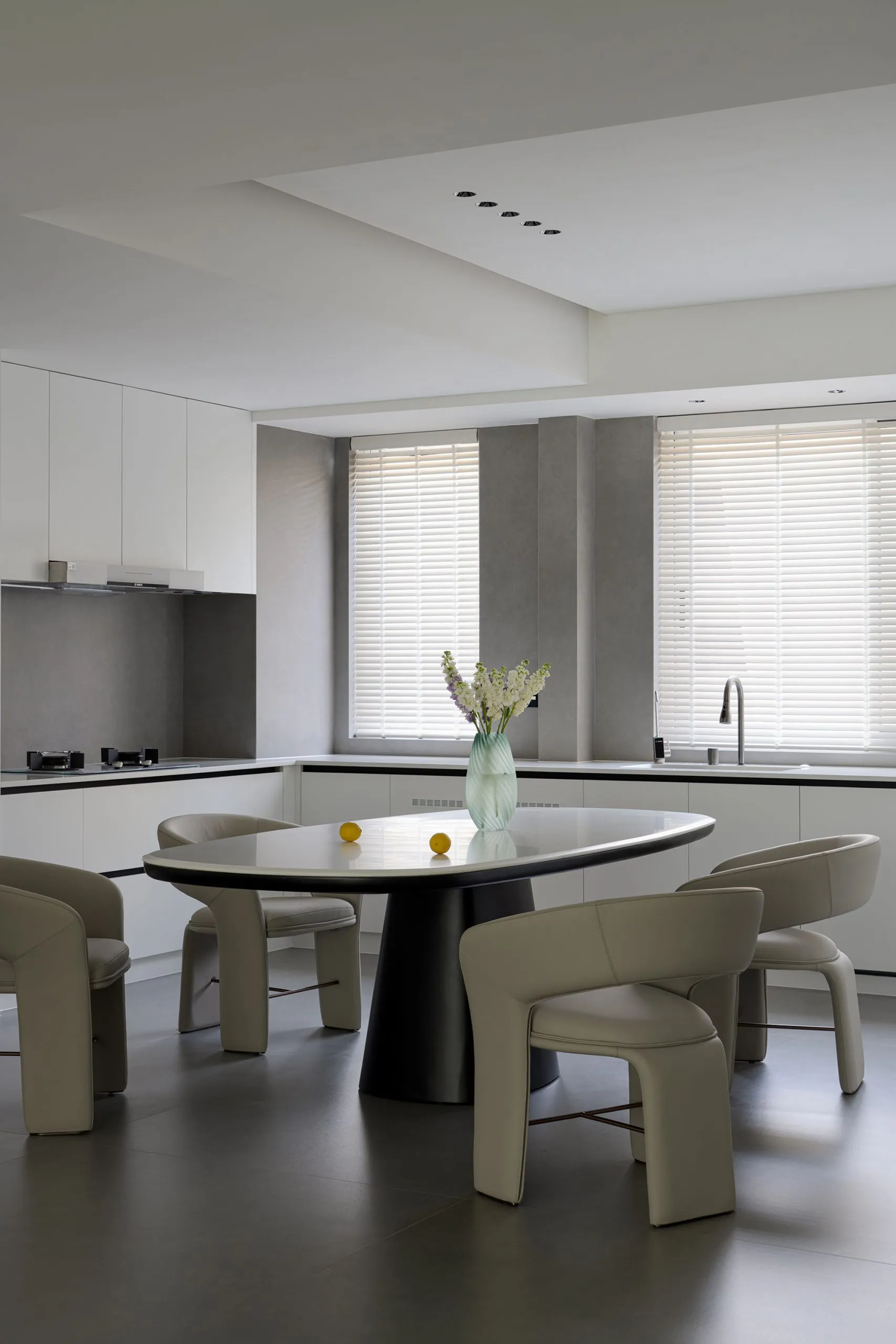 A modern minimalist residential kitchen featuring a white marble countertop and stainless steel appliances.