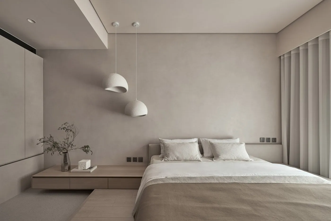 A minimalist bedroom with neutral tones and white pendant lights.