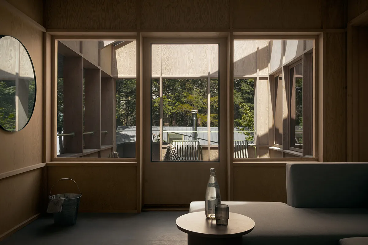 A modern interior design featuring a wooden living room with large windows and a sofa.