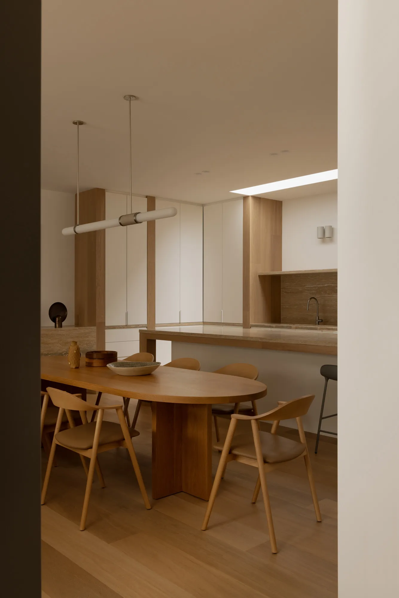 Modern minimalist living dining room featuring wooden furniture and stone countertops.
