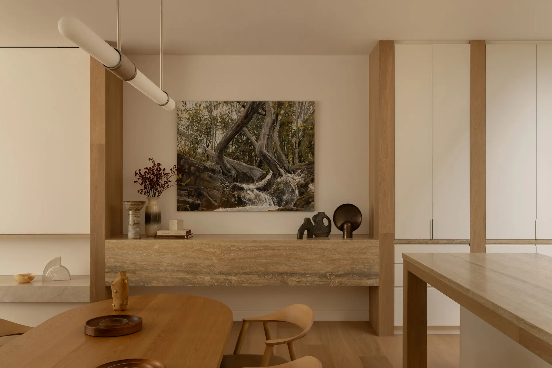 Modern living room with neutral tones, featuring a central artwork and wood accents.
