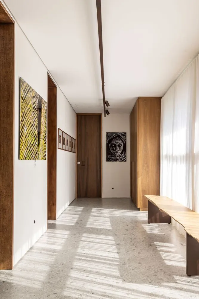 Modern minimalist corridor with wooden doors, concrete floor, and smooth finish
