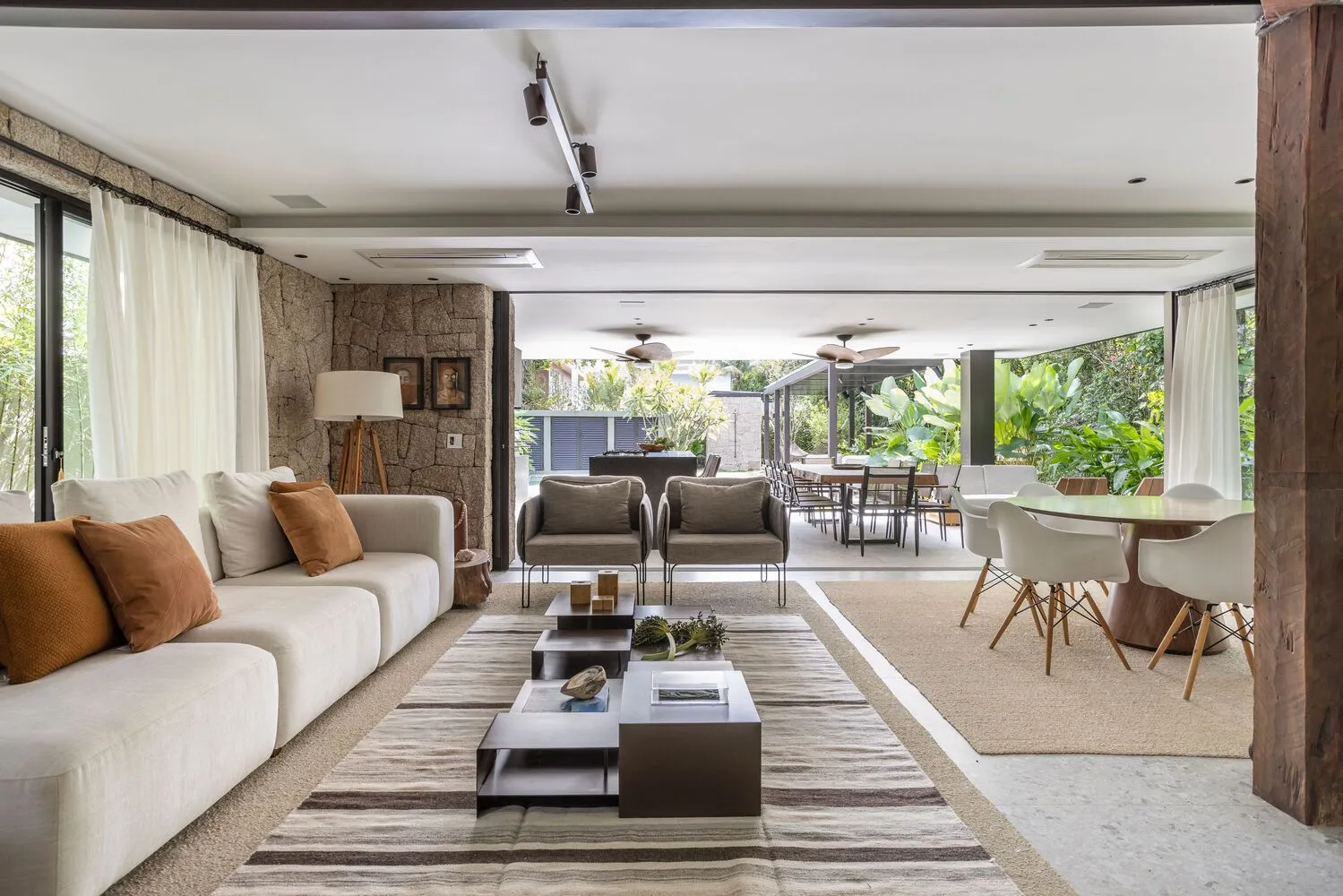 A modern minimalist living room with a traditional touch, featuring a white sofa and coffee table, wooden floor, and stone wa