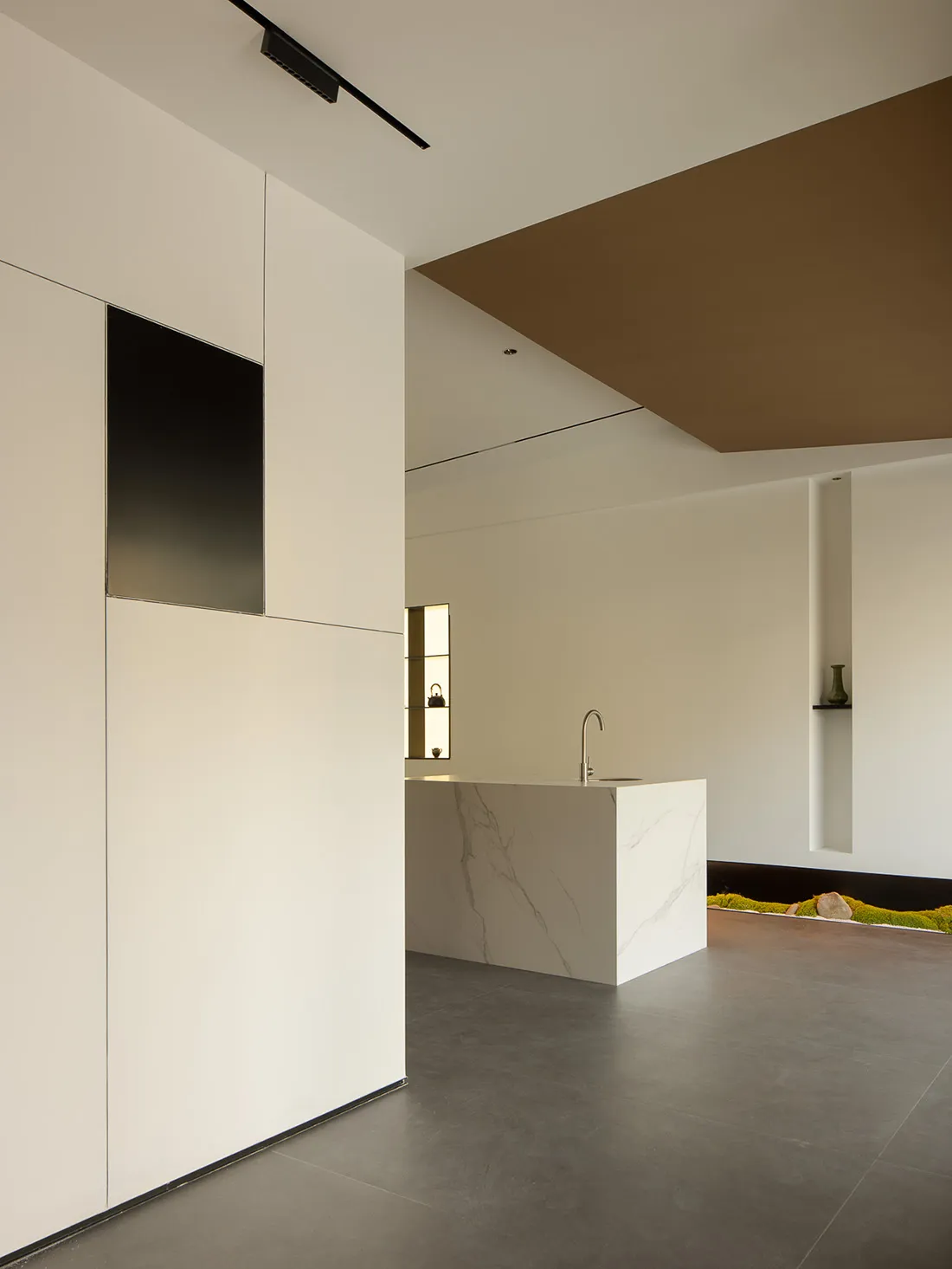 Modern kitchen with white marble countertops and white cabinetry.