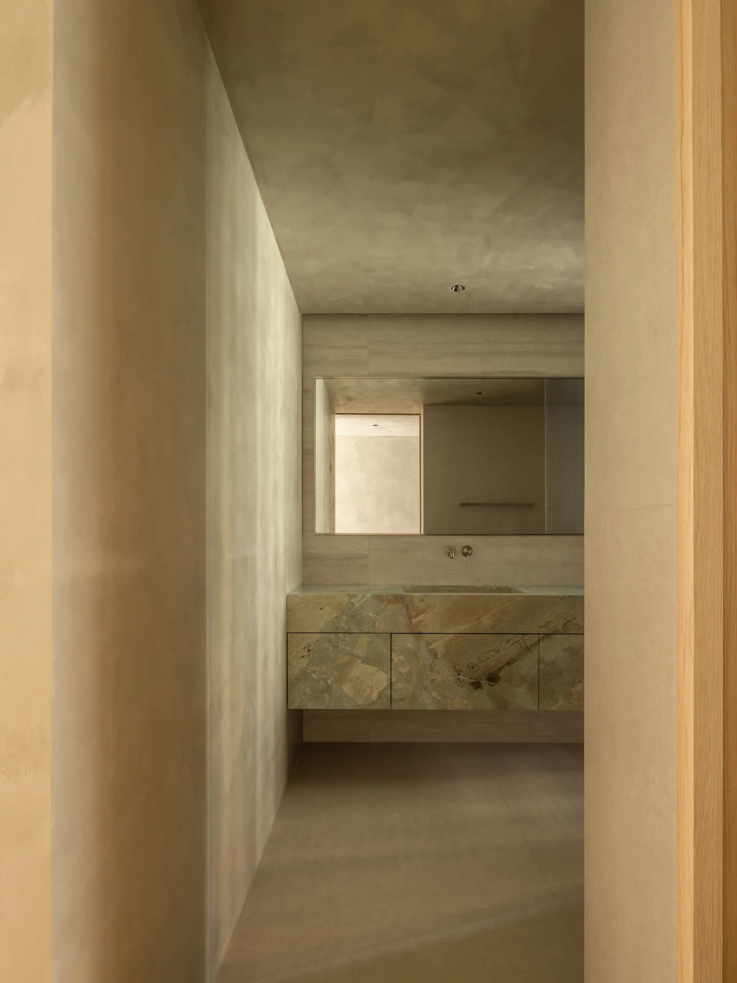 Minimalist bathroom featuring a marble countertop and sink.