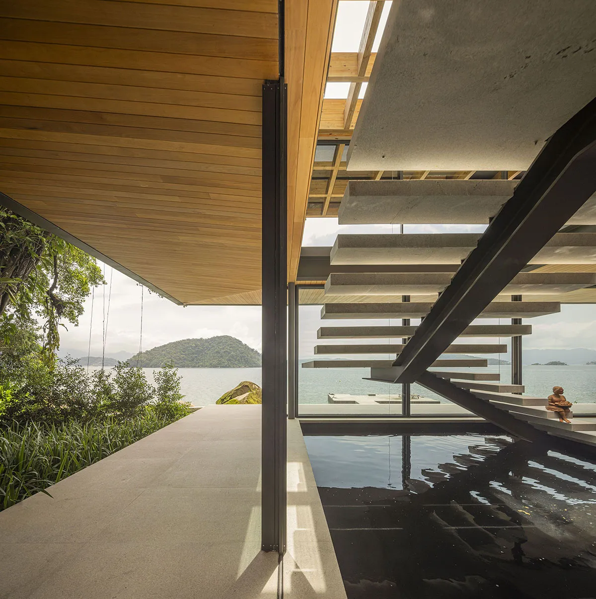 Modern house with limestone exterior and sustainable materials, featuring indoor-outdoor living spaces and sea views.
