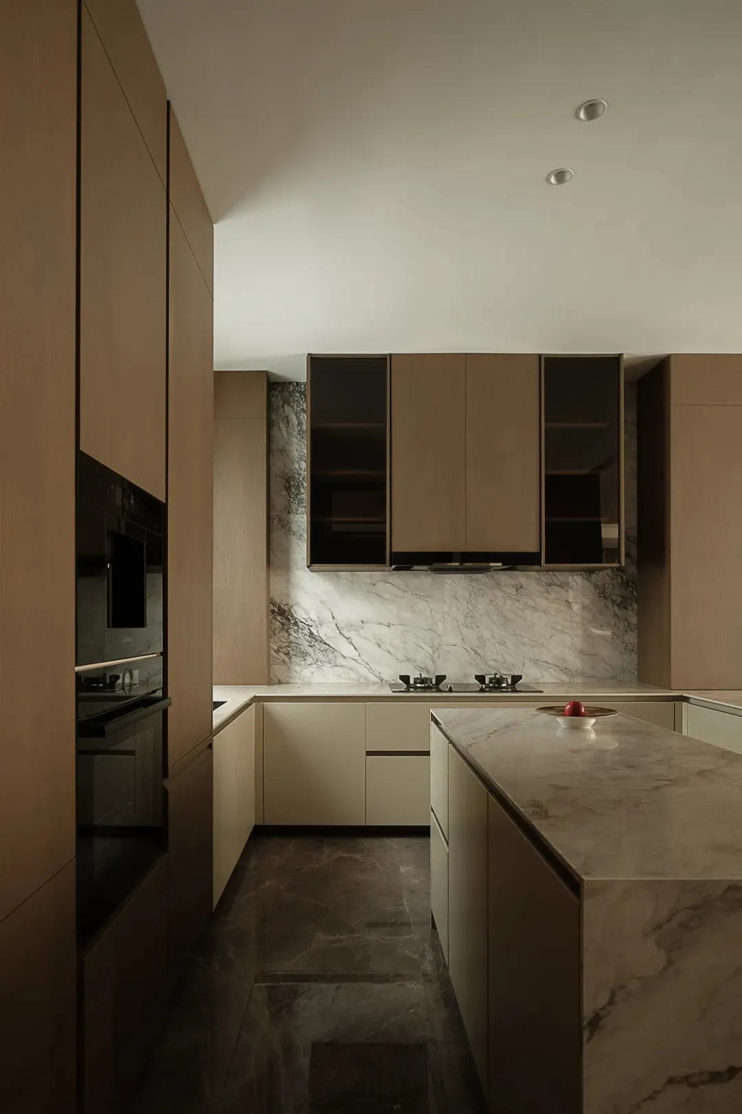 A modern residential kitchen featuring marble countertops and subway tiles on the floor.