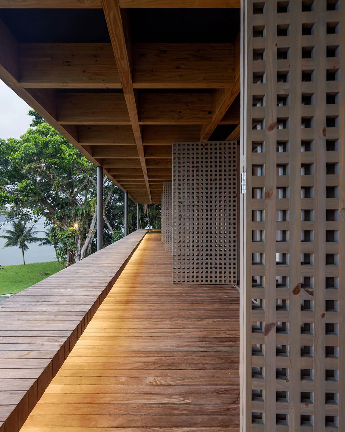 A modern wooden verandah with integrated lighting and surrounding greenery.