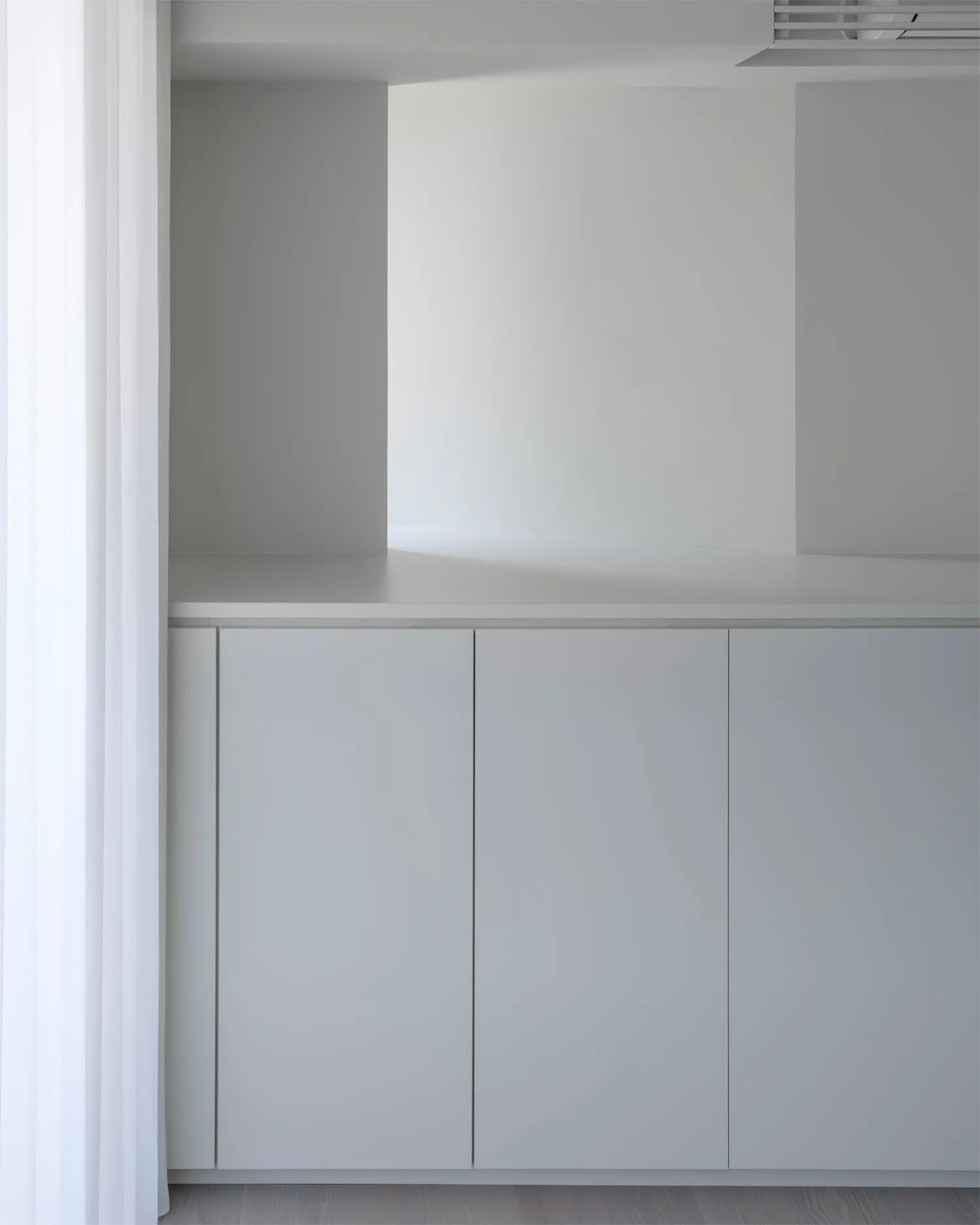 A minimalist interior space with concrete walls and floor.