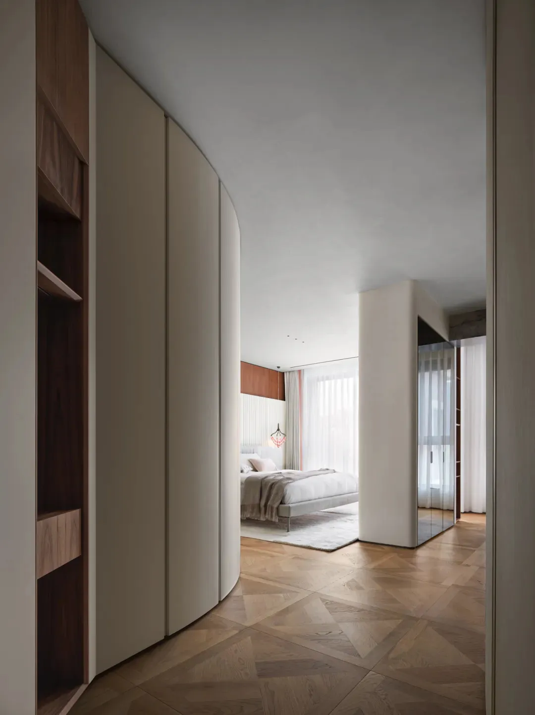 A modern bedroom featuring wood flooring and minimalist furniture.