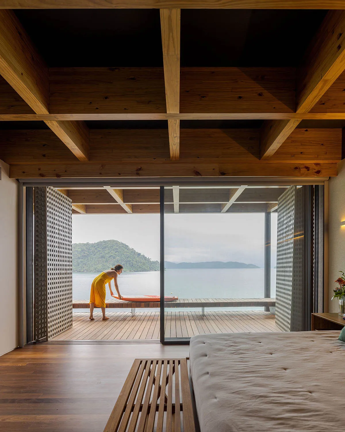 A modern hotel room featuring wooden furniture and a sea view.
