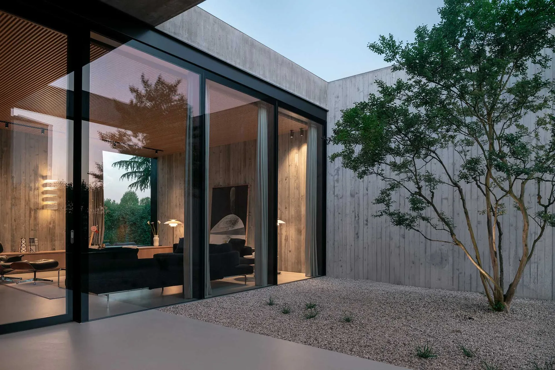Modern residential interior with concrete walls and glass sliding doors.