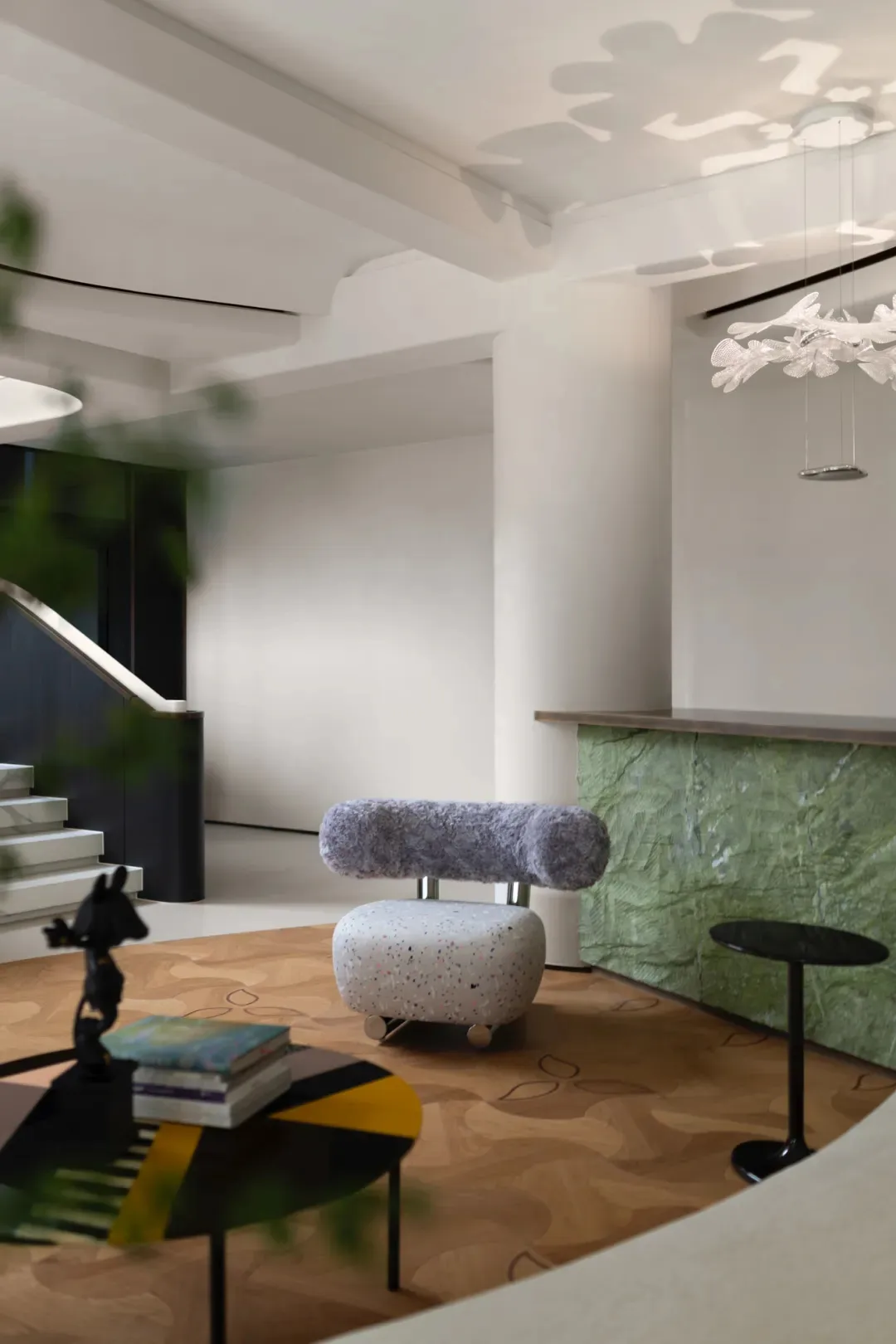 A modern living room featuring a terrazzo and marble interior design with a unique chair and table setup.