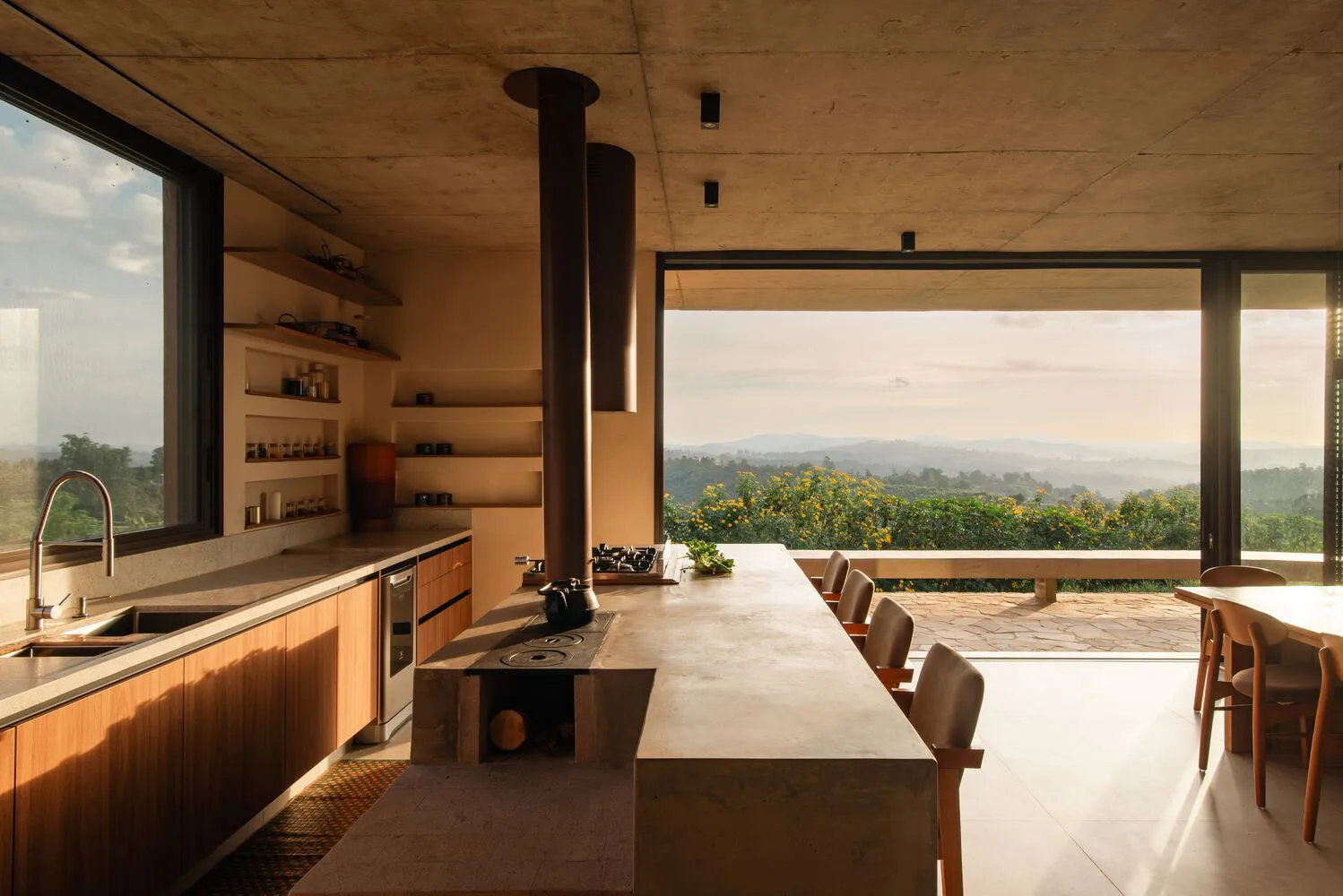 A modern residential kitchen featuring concrete and wooden elements.
