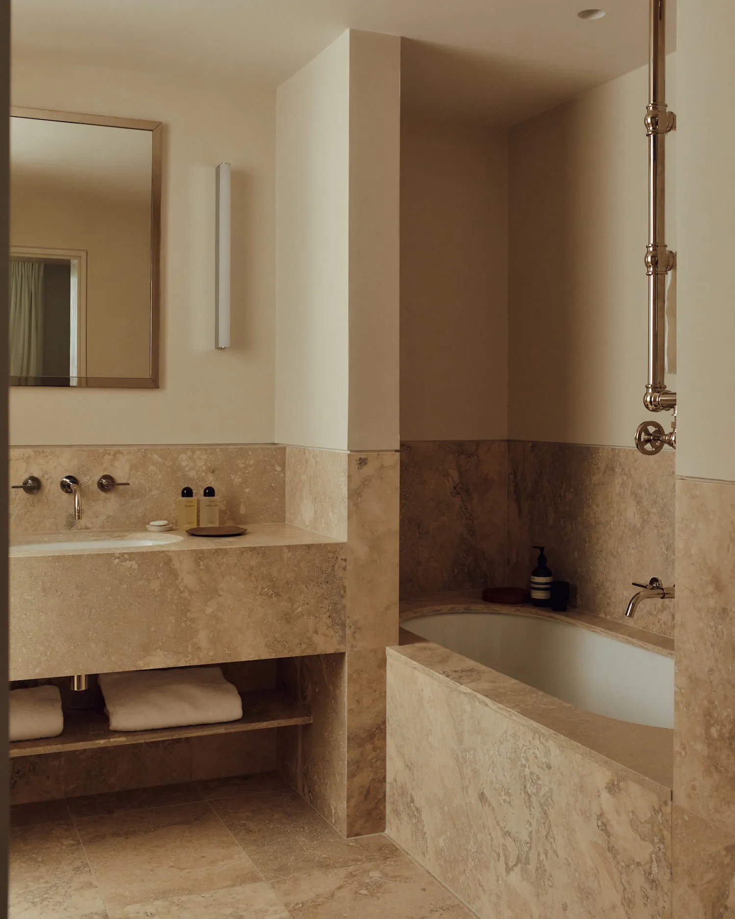 Modern minimalist bathroom featuring marble tiles and fixtures.