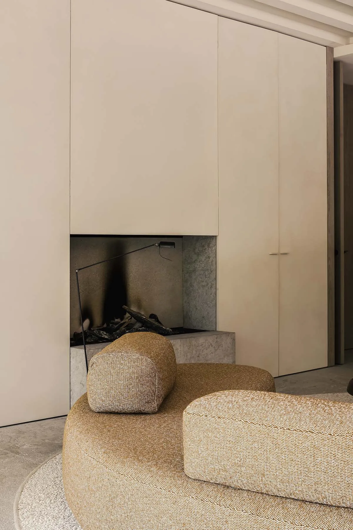 Modern minimalist living room featuring fabric seating and concrete fireplace