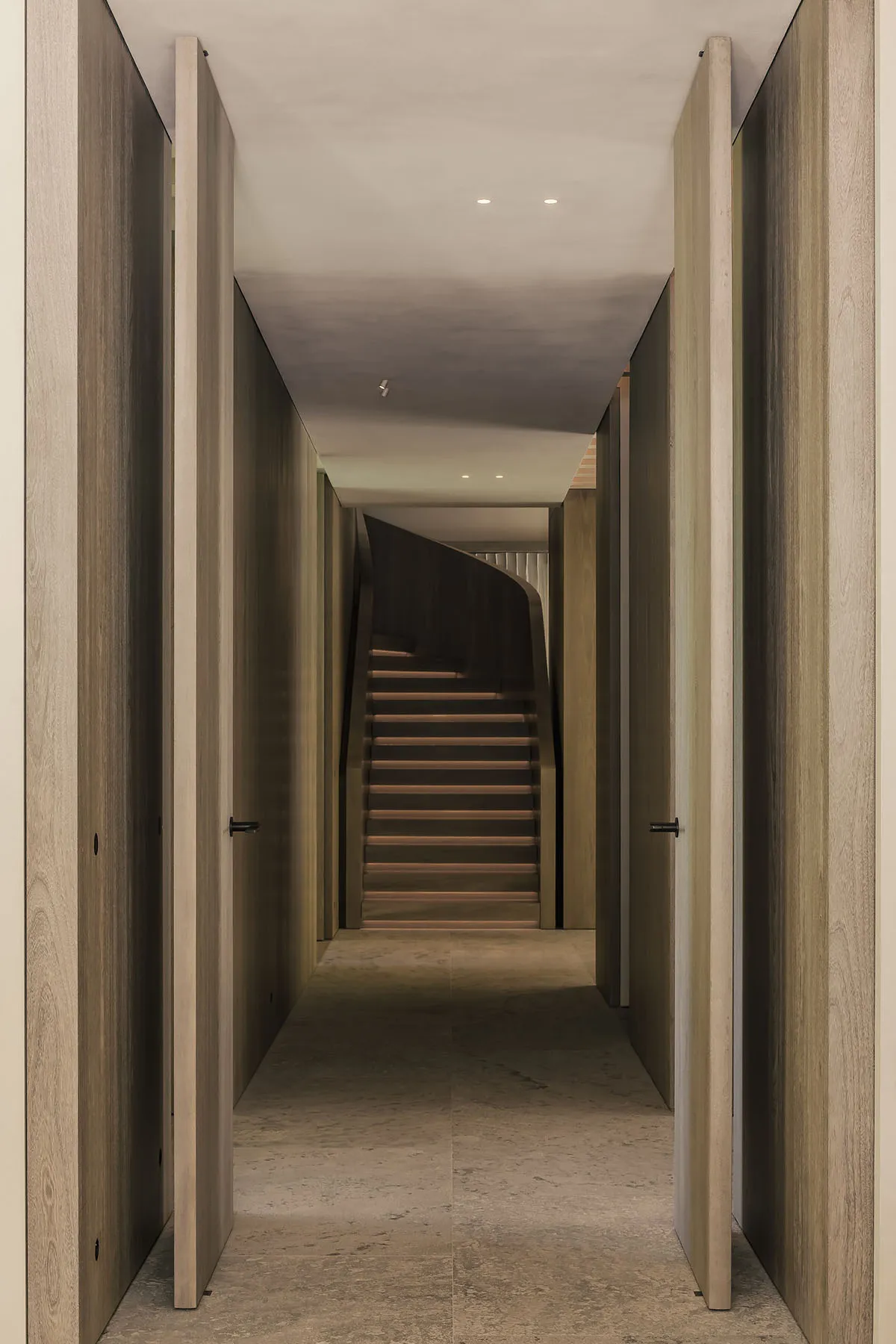 A modern interior space with a wooden staircase and walls.