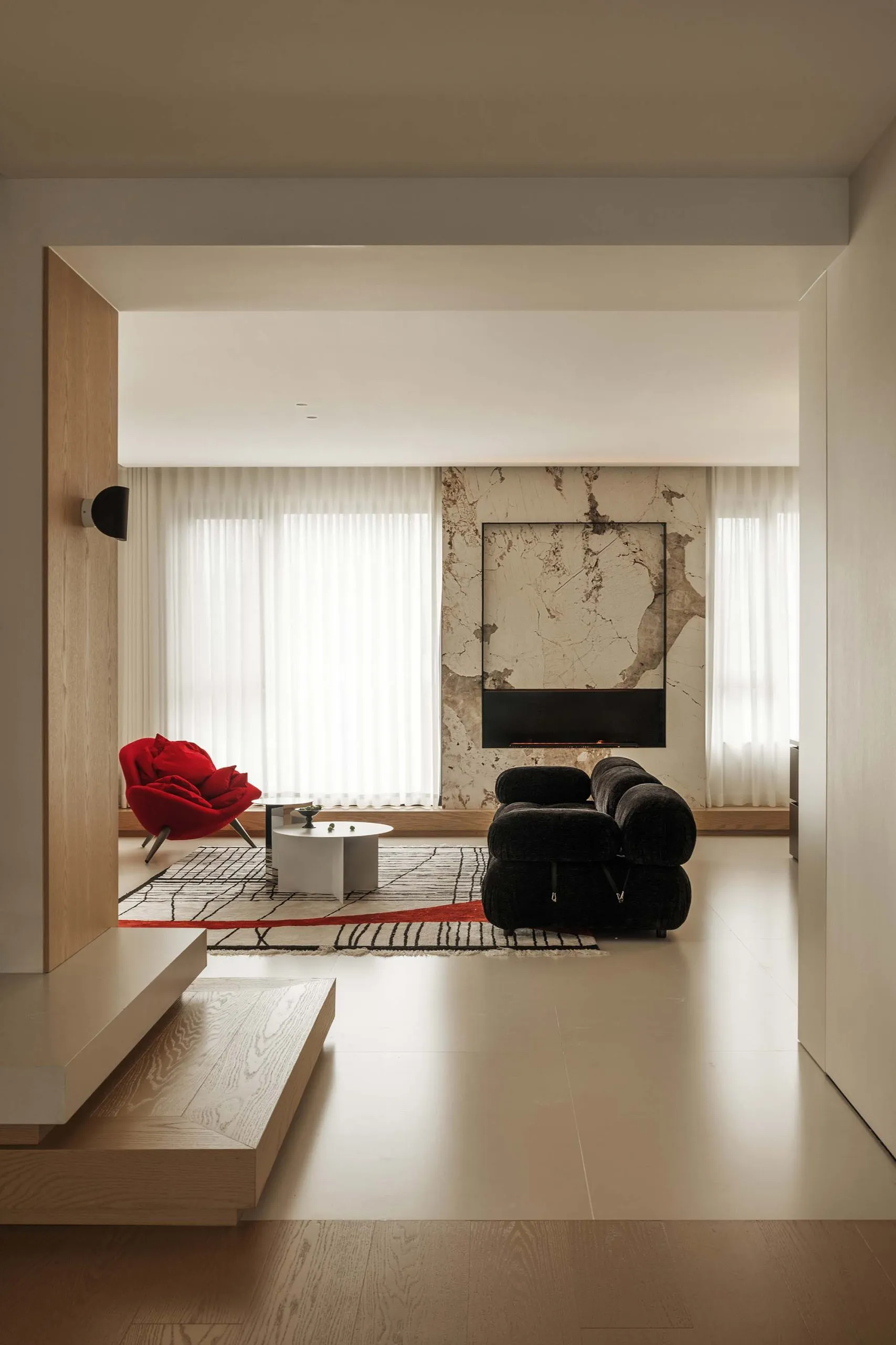A modern living room featuring wooden flooring, marble accent wall, and vinyl flooring.