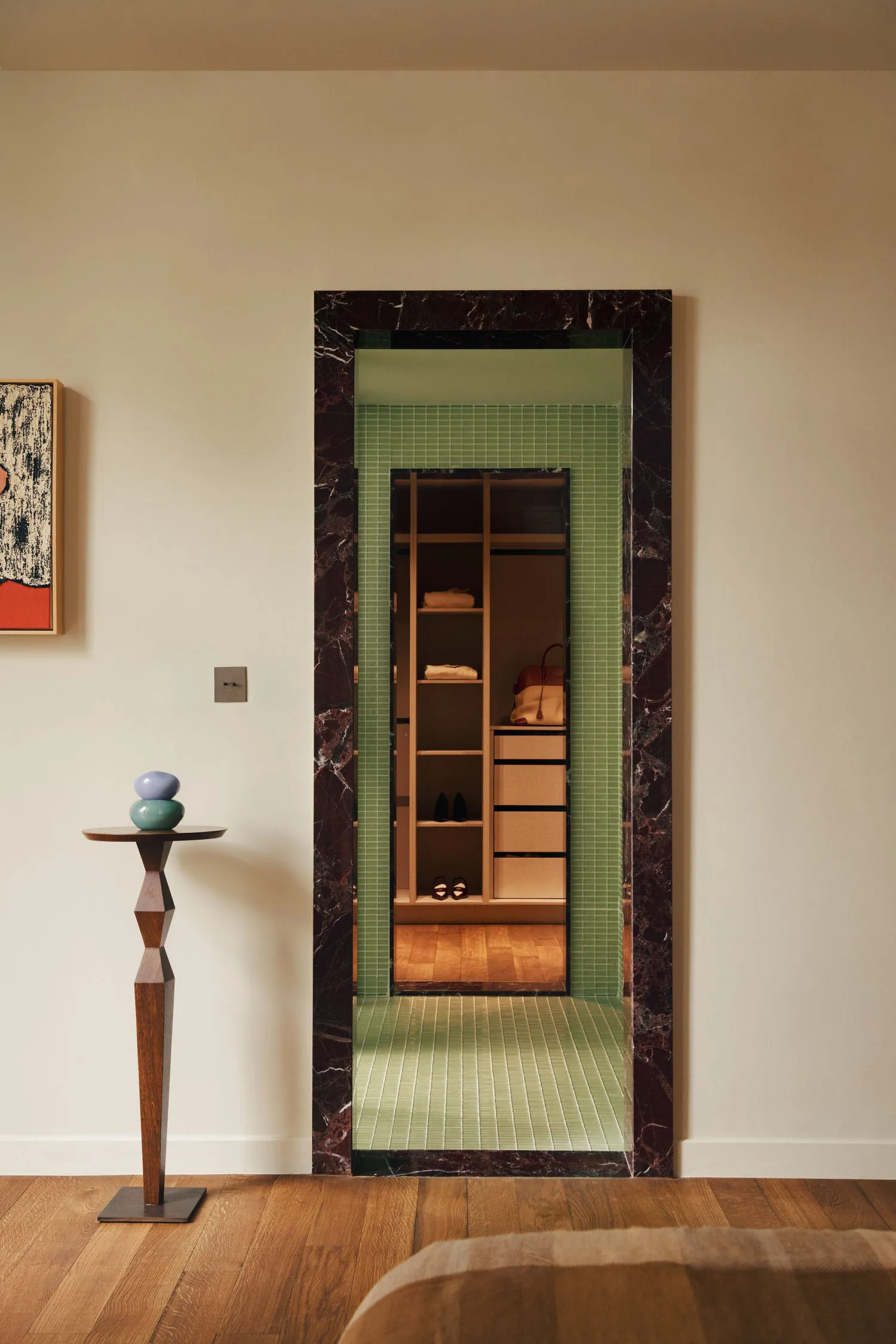 Modern closet display with marble frame and green tile flooring