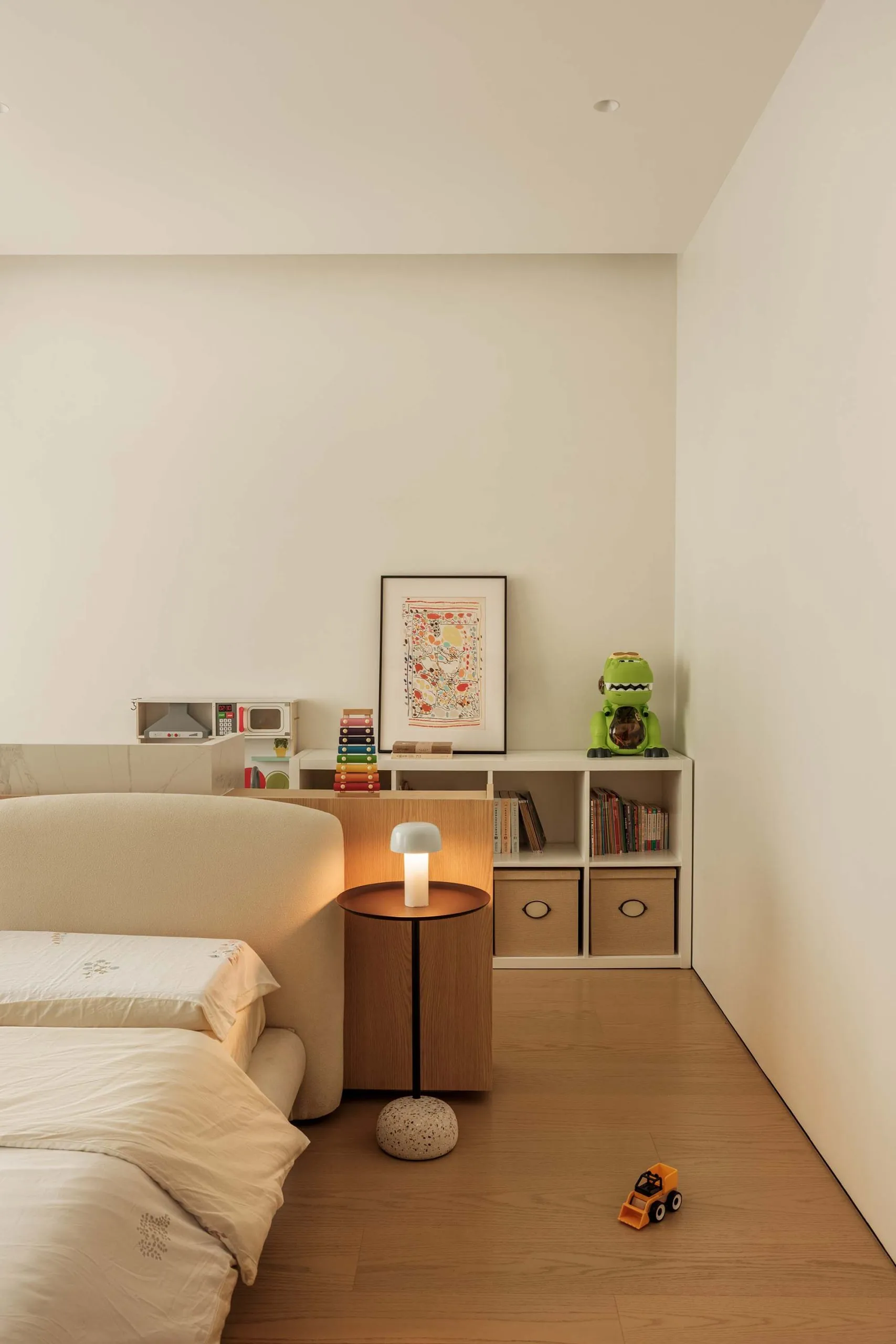 A modern bedroom featuring white walls, a beige sofa, and a wooden floor.