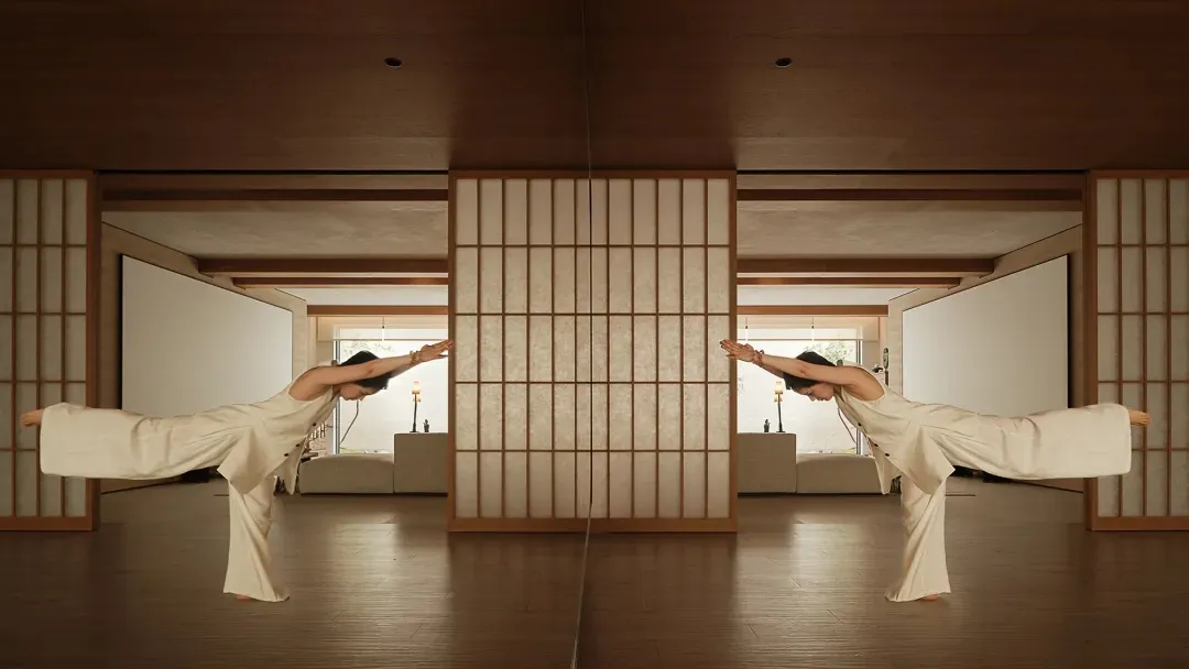 A person practicing yoga on wooden flooring in a spacious studio with wooden dividers.