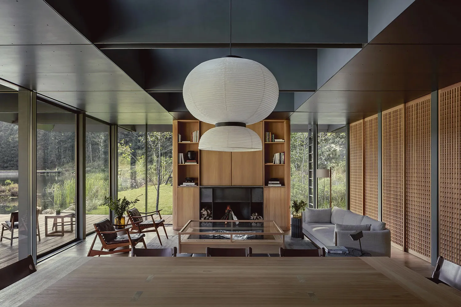 Modern interior design featuring a living room with wood finishes, a glass coffee table, and a fireplace.