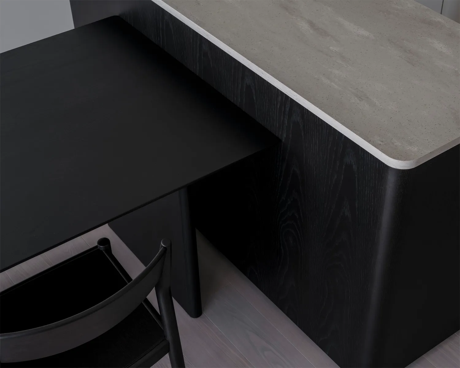 A modern workstation with a concrete countertop and black wooden elements.