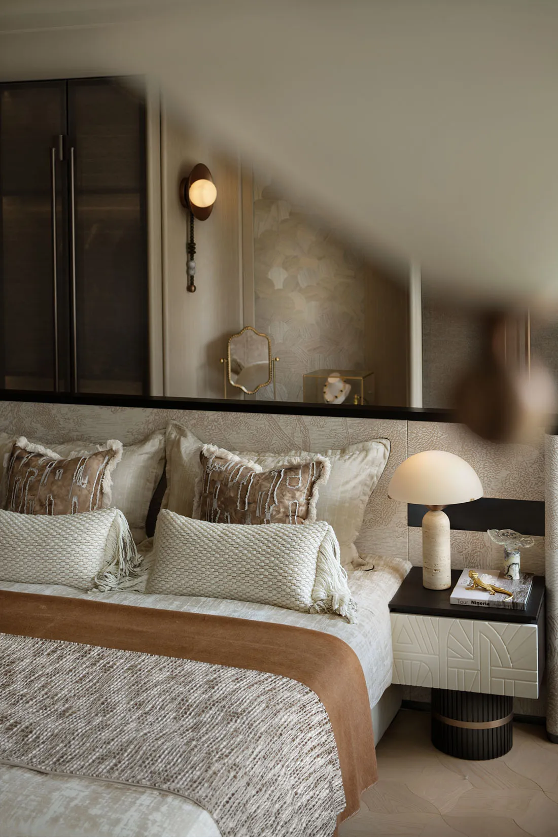 A modern bedroom featuring patterned fabrics and a cozy ambiance.