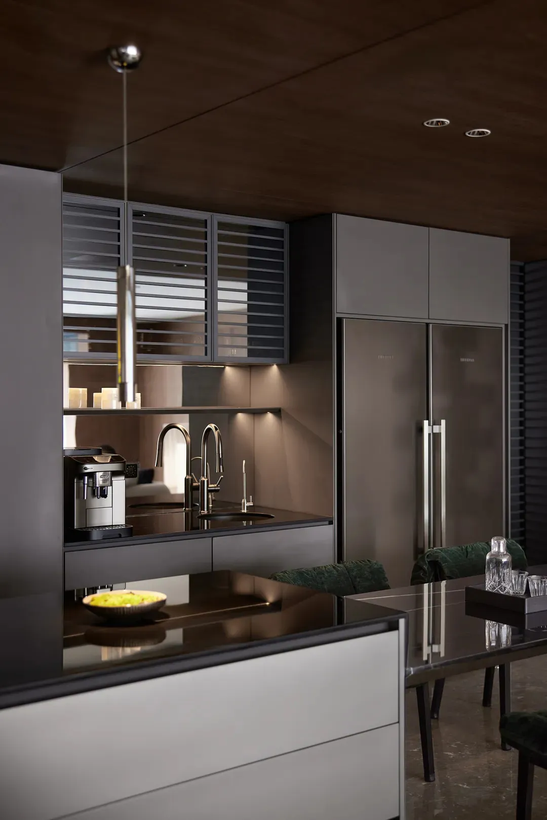 Modern black kitchen interior with metallic cabinets and stainless steel appliances.