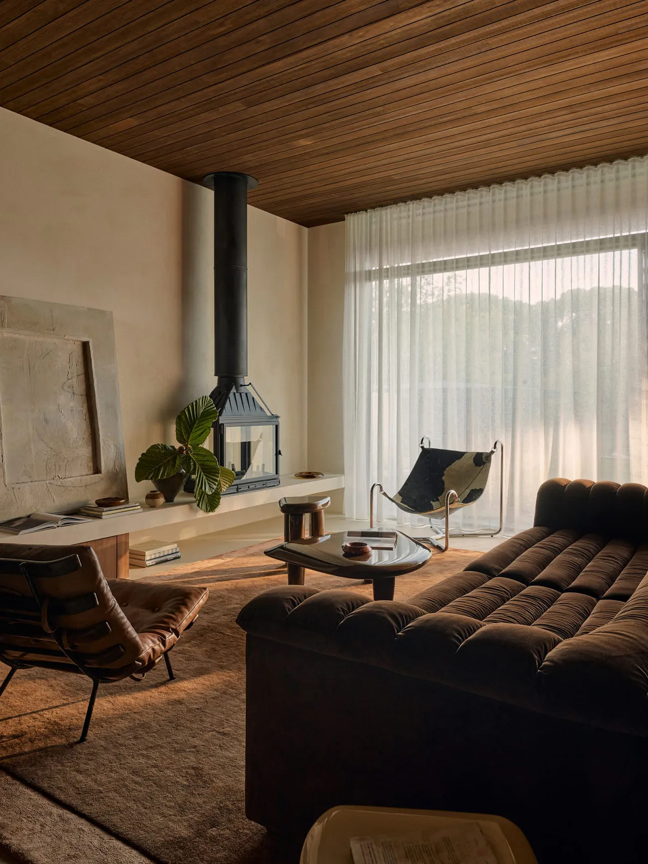 A modern living room featuring a cozy sofa adorned with plush cushions, set against a backdrop of warm wooden walls and ceili