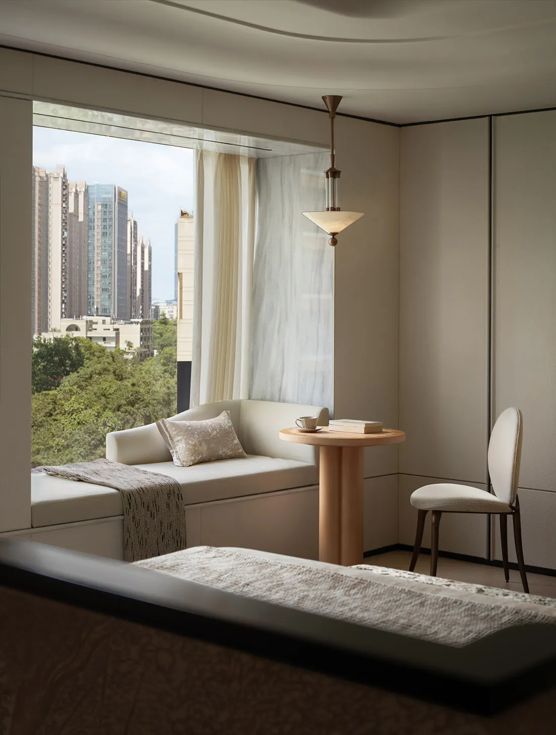 Modern living room featuring a cozy window sill with white upholstery, a small wooden table, and a comfortable seating area.