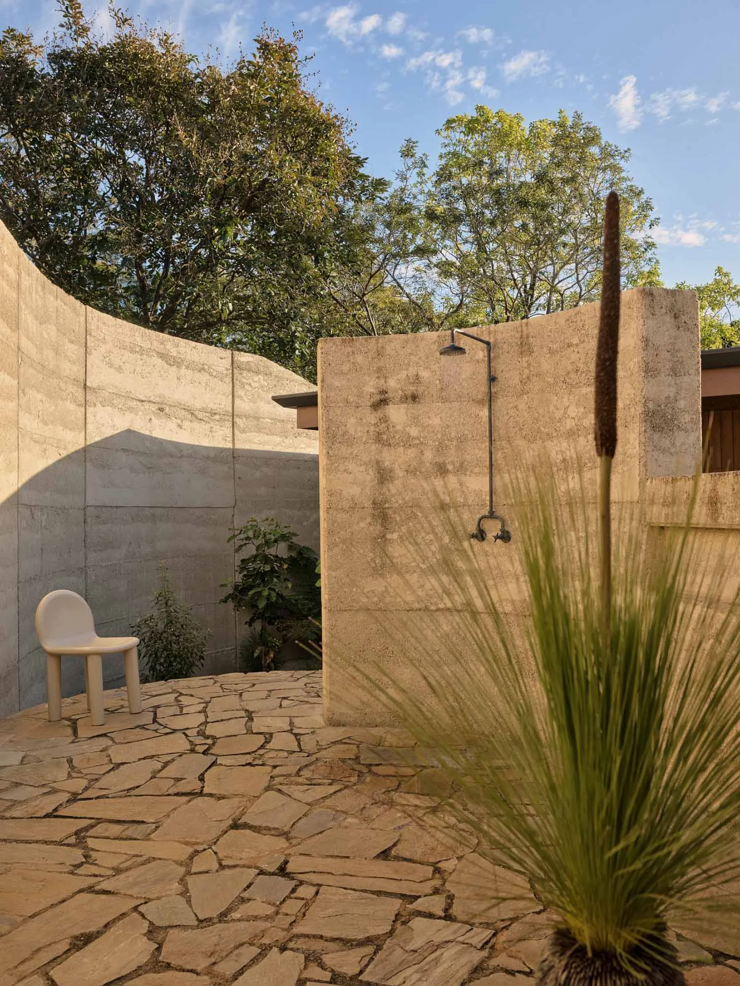 An outdoor shower area with minimalist design and concrete walls.