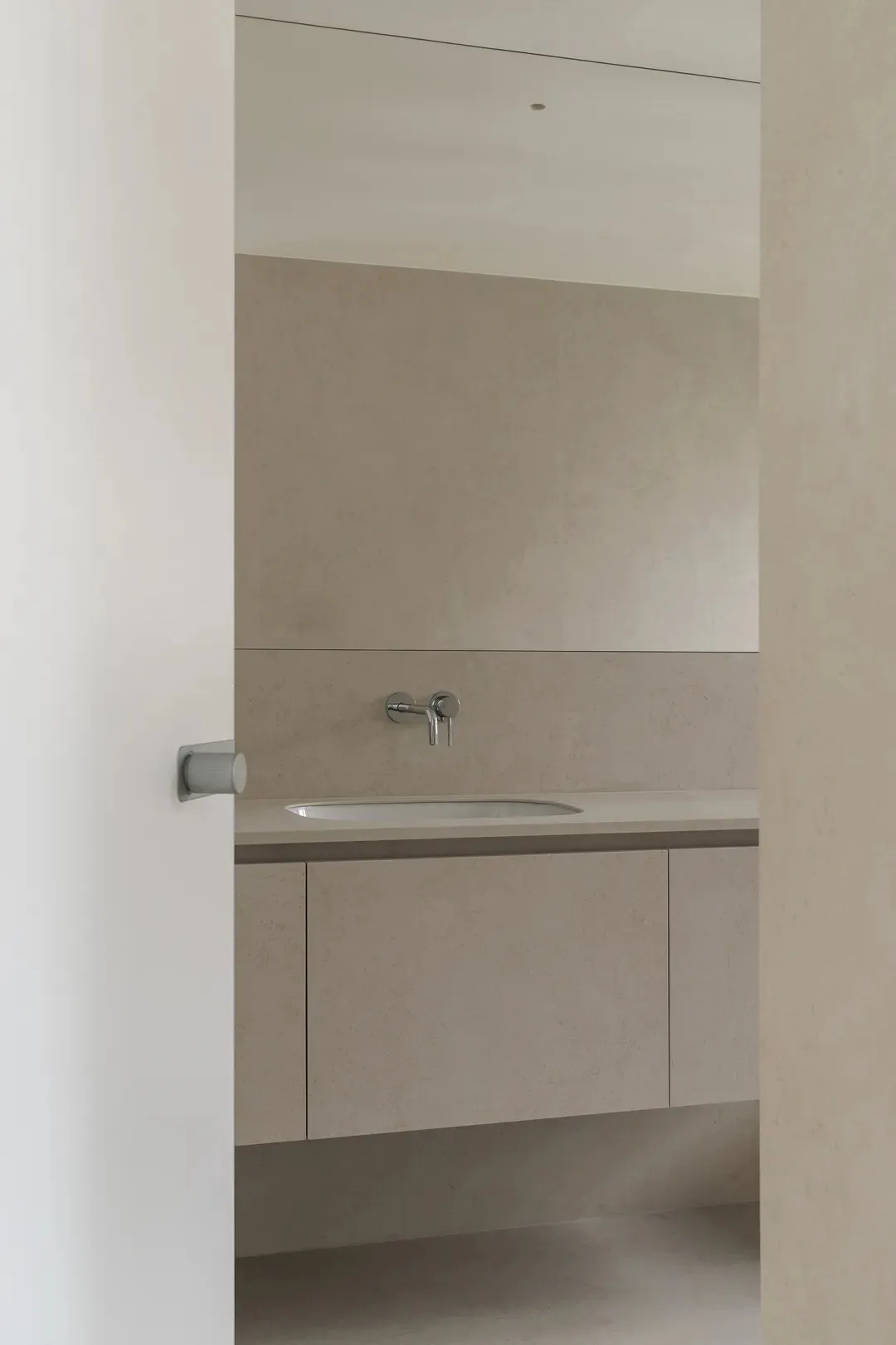 Modern minimalist bathroom with a concrete countertop and sink, no visible clutter or decorations.