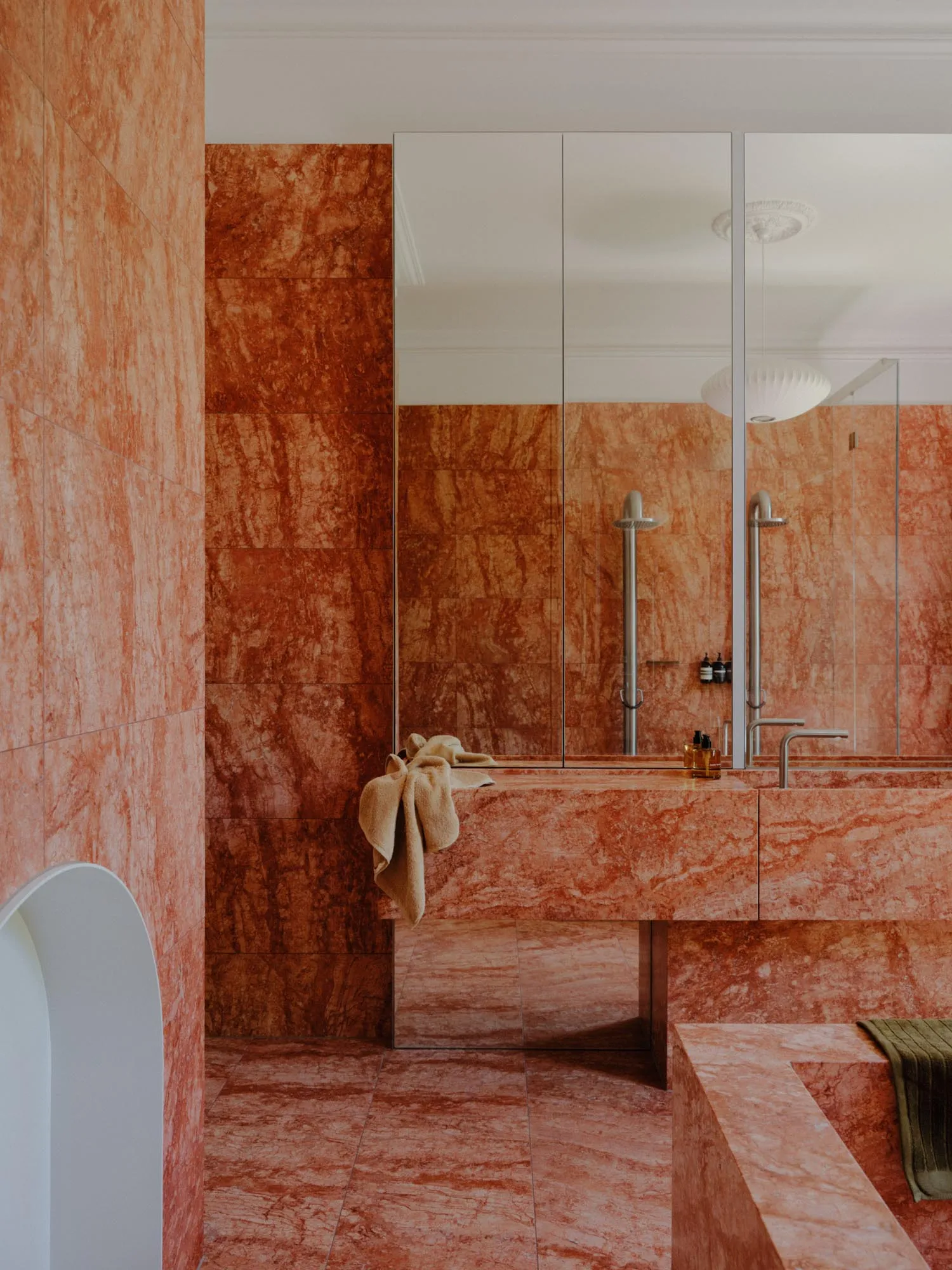Modern bathroom interior with marble walls and flooring, featuring a sleek, minimalist design.