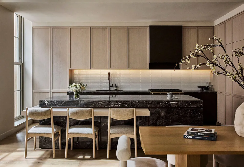 A minimalist residential kitchen featuring marble countertops and white cabinetry.