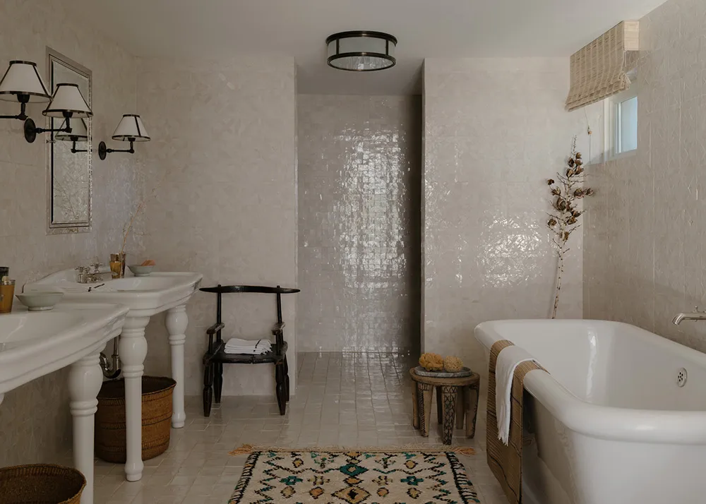 一間現代衛浴,鋪設白瓷磚,配有白色浴缸與裝飾元素。