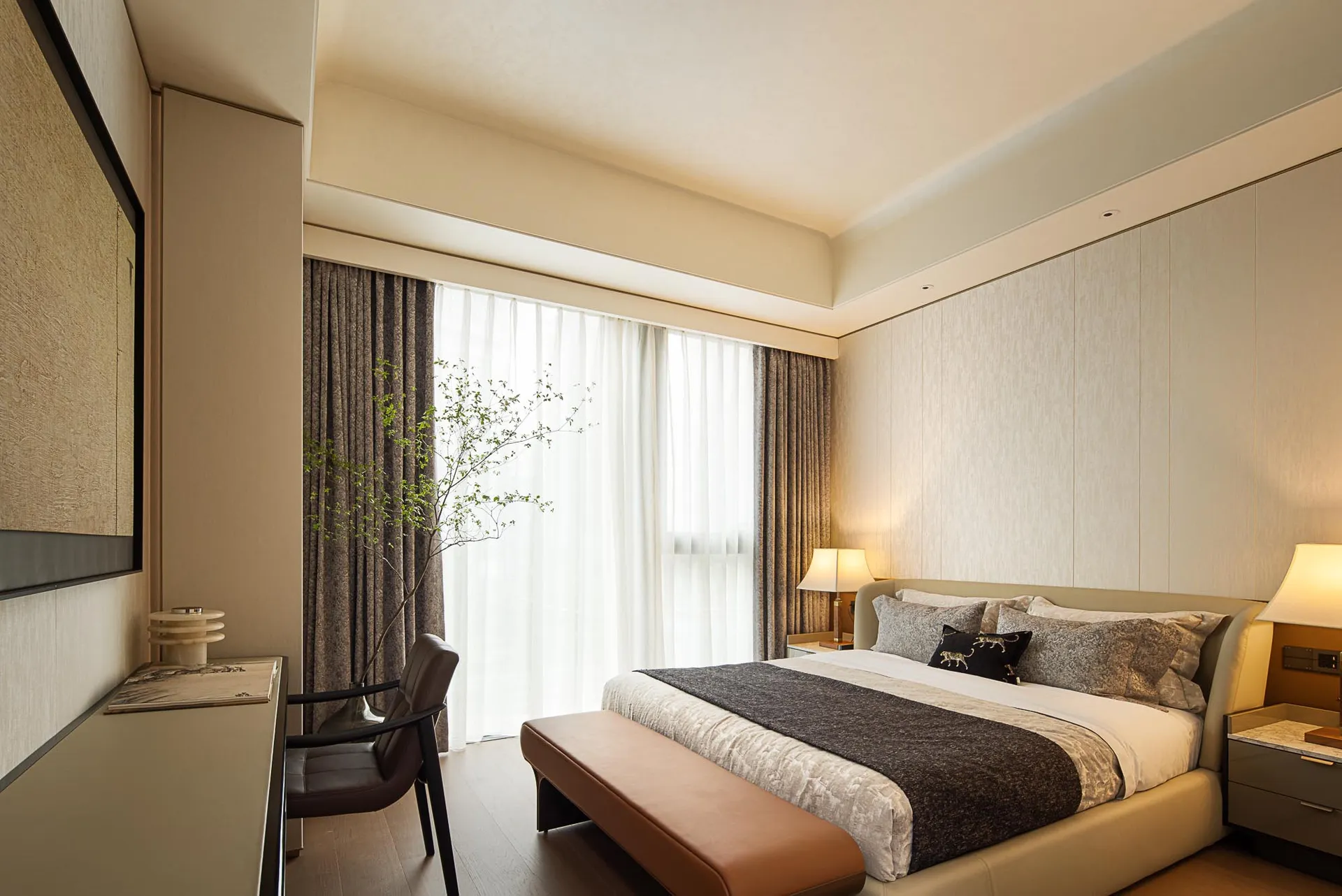 A modern bedroom with fabric finishes and a large window.