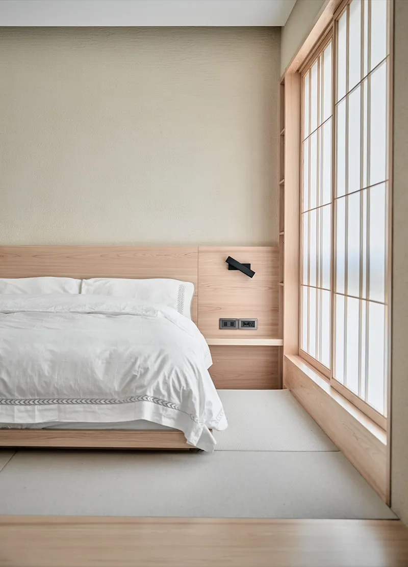 Minimalist bedroom featuring a wooden platform bed with white bedding.