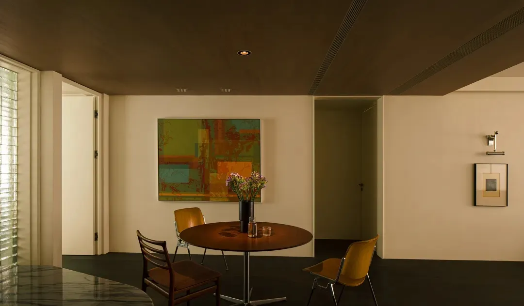 A modern residential interior featuring wood, glass, and metal furnishings