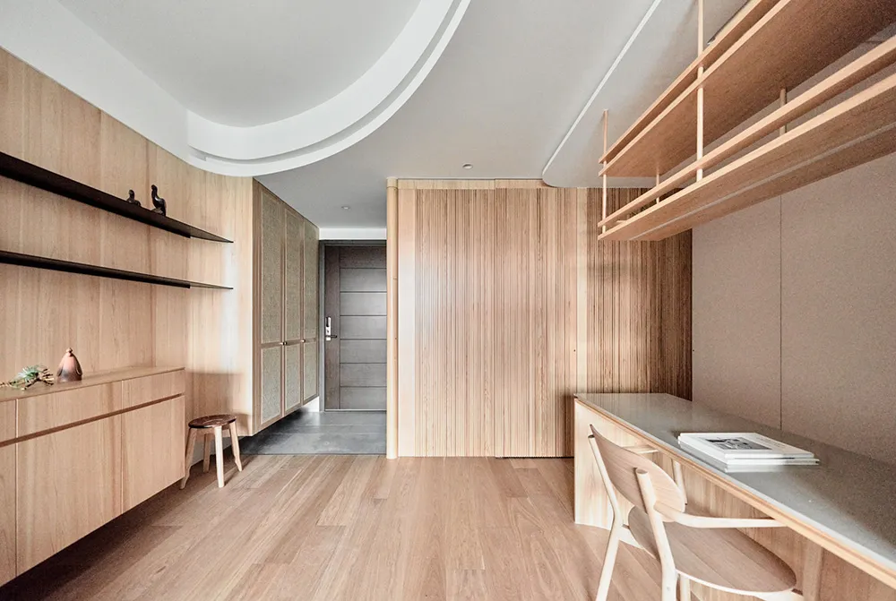 Modern minimalist office space featuring wood finishes and open shelving.