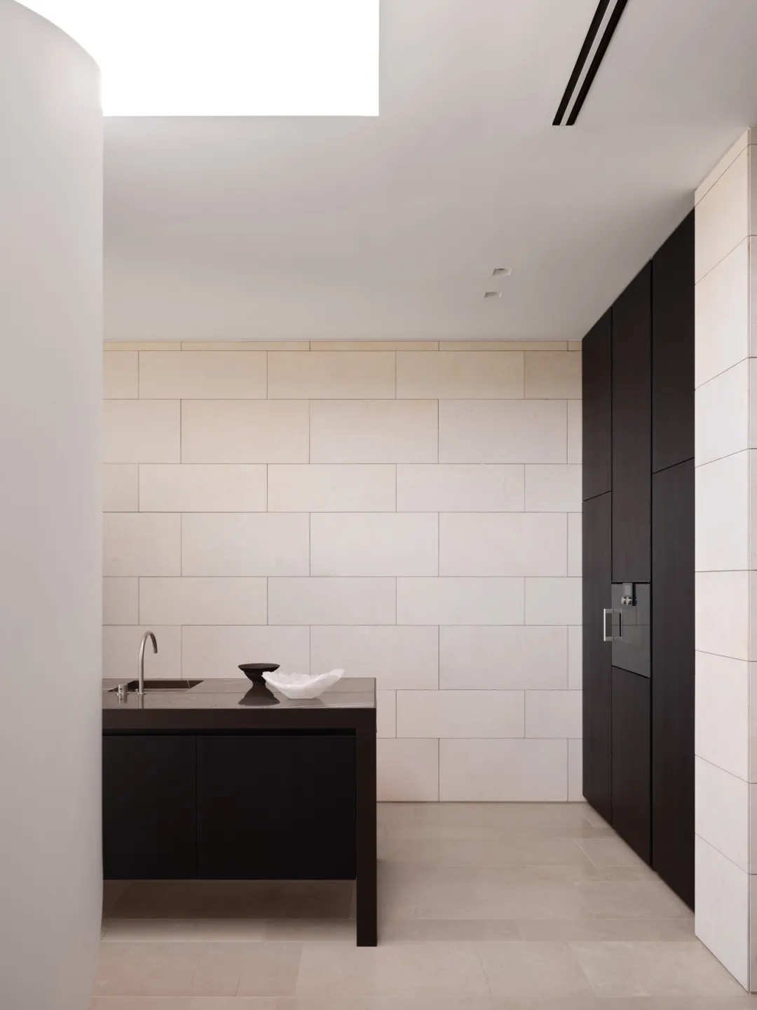 A minimalist modern kitchen with marble countertops and backsplash.
