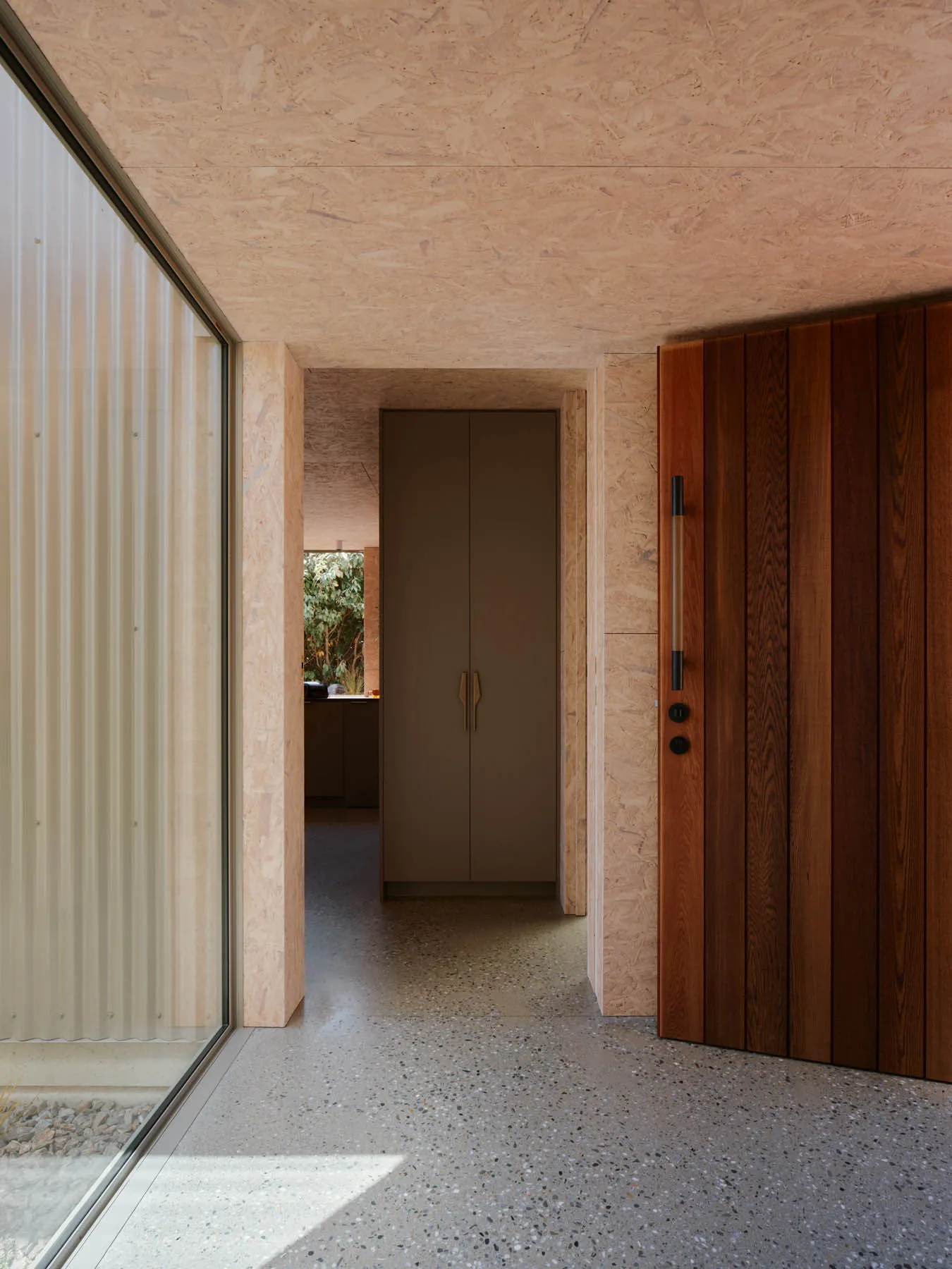A modern entrance with wooden materials and OSB walls.