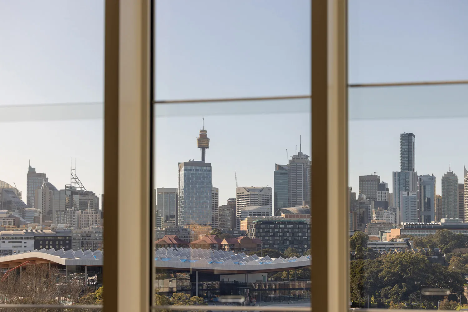 A modern cityscape view from a window, featuring glass and steel skyscrapers.