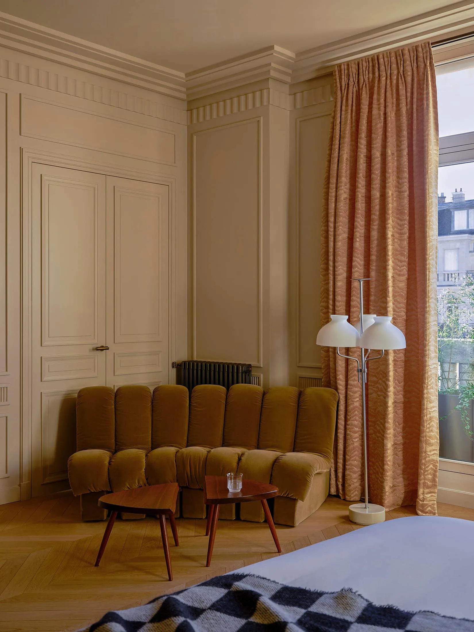 A modern hotel bedroom featuring a comfortable seating area, a stylish coffee table, and elegant curtains.