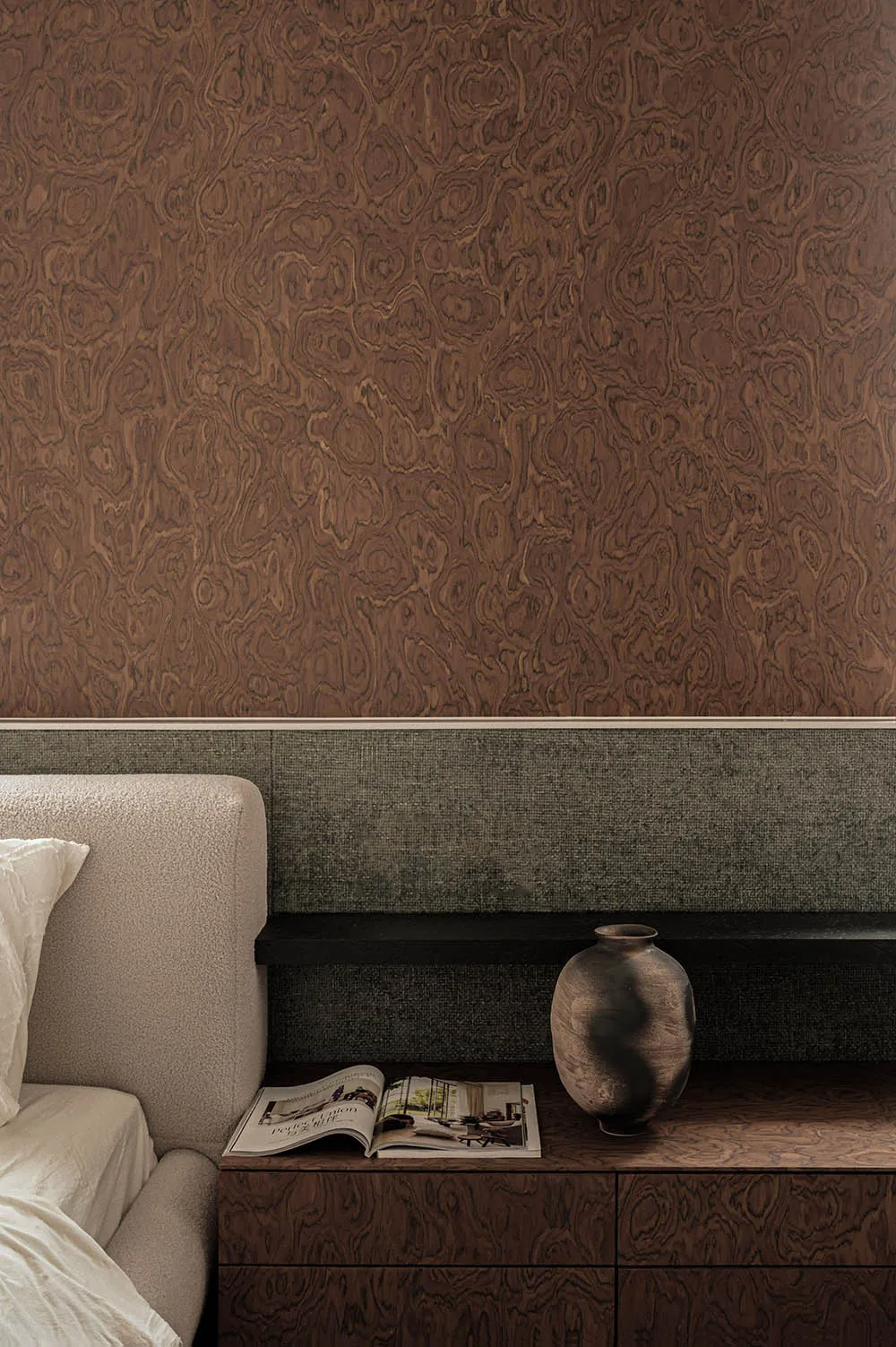 Modern minimalist bedroom features a wood-textured wall and nightstand with a vase and open magazine.