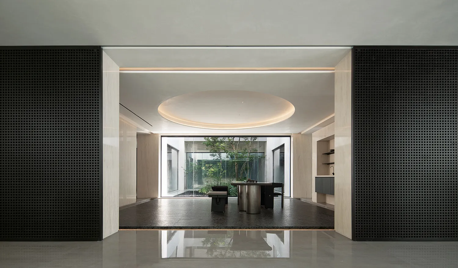 Modern living room with concrete walls and floor, featuring a white sectional sofa, black coffee table, and large windows wit