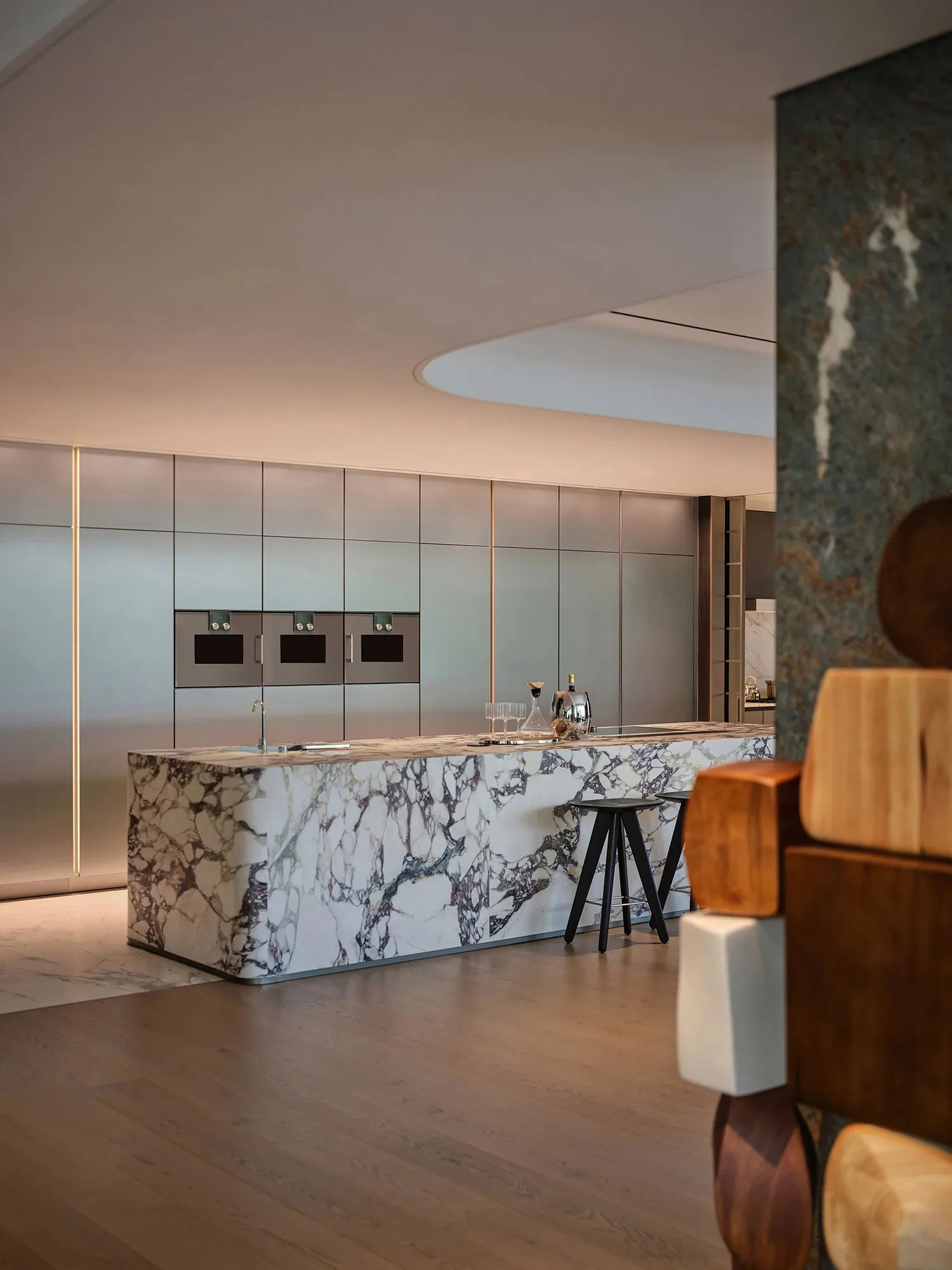 Modern minimalist kitchen featuring marble countertop and stainless steel appliances.