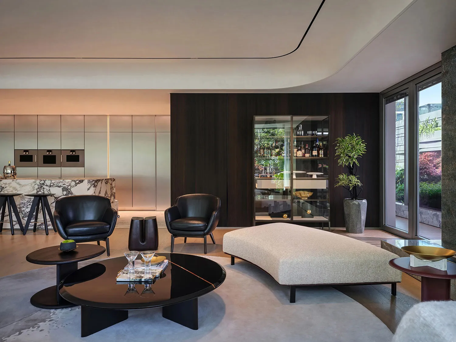 A modern residential lobby features contemporary furniture, a glass display cabinet, and a large window overlooking an outdoo