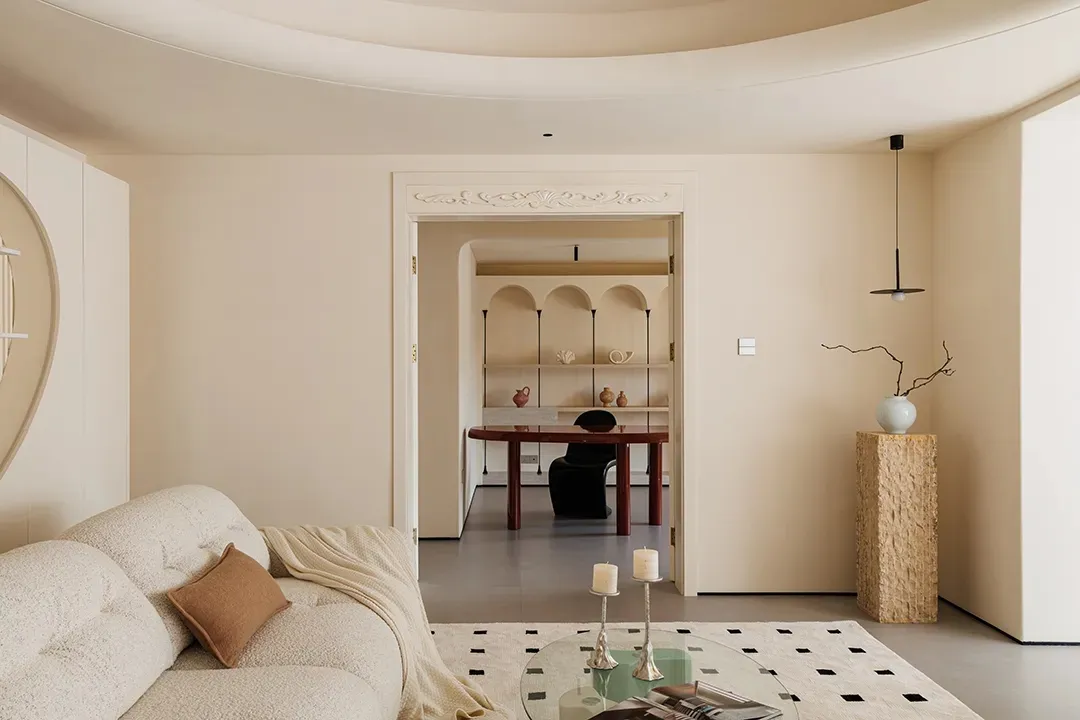 A modern living room with a neutral color palette and a glass coffee table.